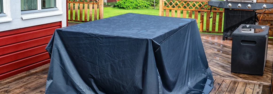 Abgedeckter Gartentisch auf einer Terrasse